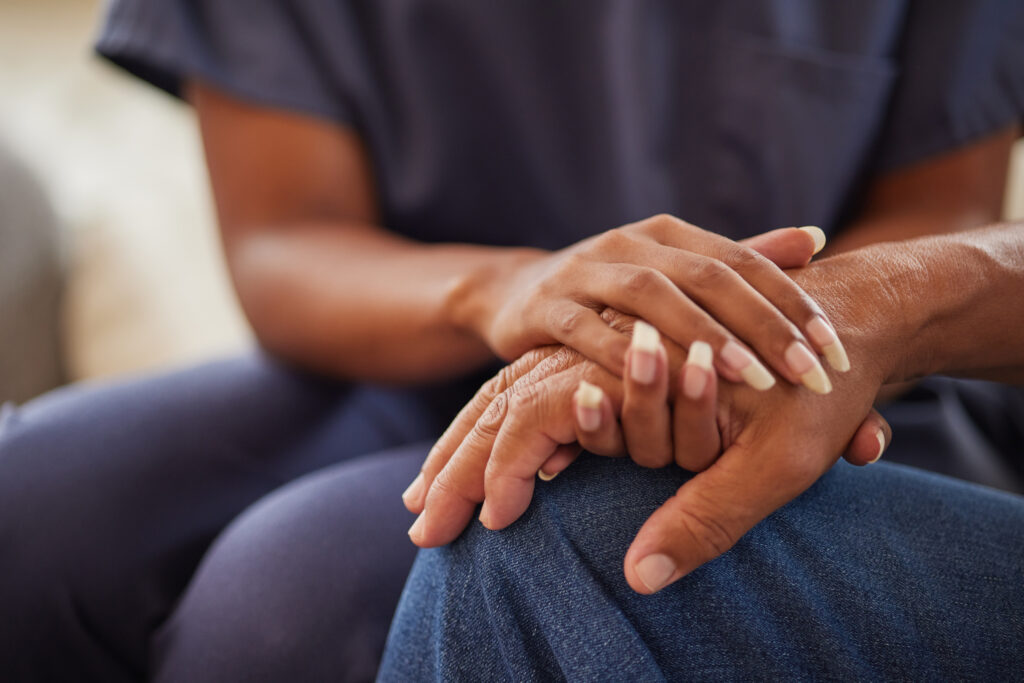 Support, trust and empathy during counseling or therapy with a nurse and senior man in retirement home with healthcare insurance. Hands of caregiver and patient with compassion, help and hospice care.